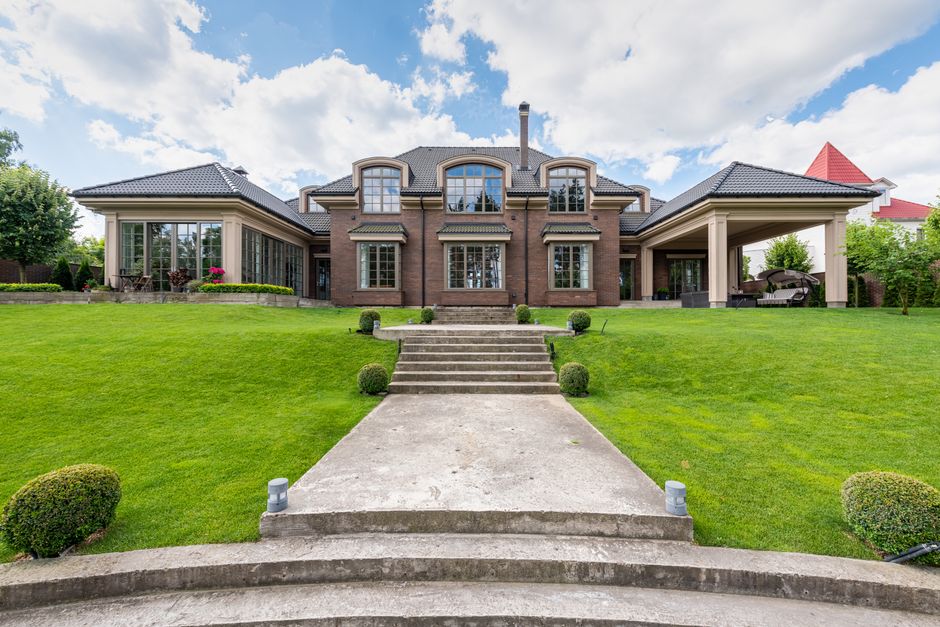 Large detached brick house with a sweeping front lawn